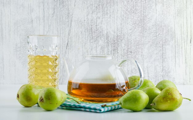 Pere con bevanda, vista laterale dell'asciugamano di cucina su fondo bianco e grungy