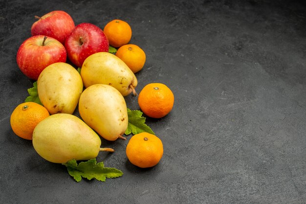 Pere dolci fresche di vista frontale con i mandarini e le mele sull'albero maturo di colore della frutta del fondo grigio