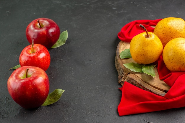 Pere dolci fresche di vista frontale con le mele sull'albero morbido fresco maturo rosso della tavola grigia