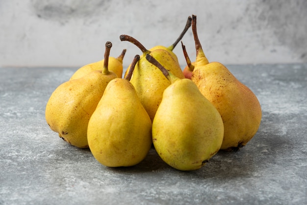 Pere gialle in magazzino sulla tavola di cemento.