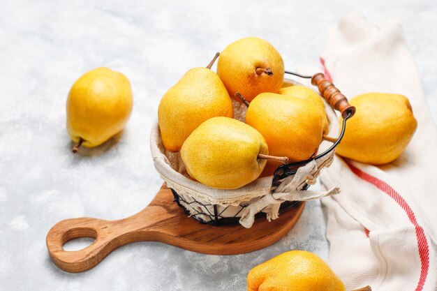 Pere organiche fresche su calcestruzzo grigio bianco. Messa a fuoco selettiva.