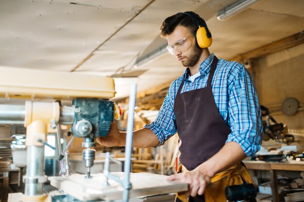 Perforazione della tavola di legno in officina