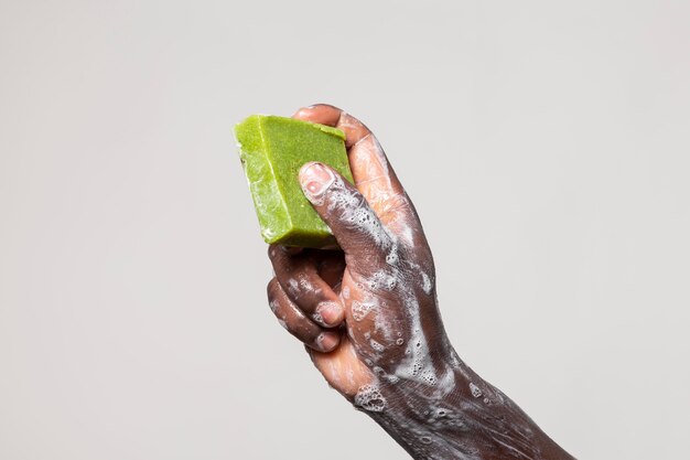 Persona africana che si lava le mani con sapone isolato su bianco