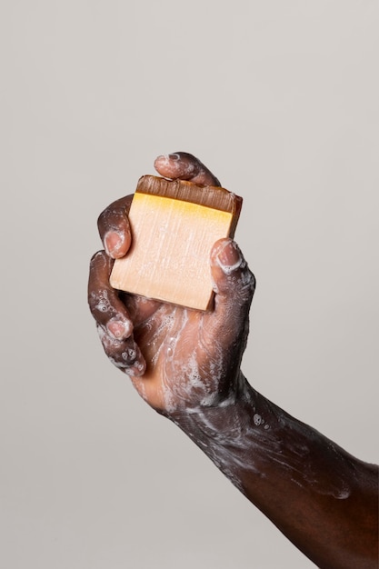 Persona africana che si lava le mani con sapone isolato su bianco