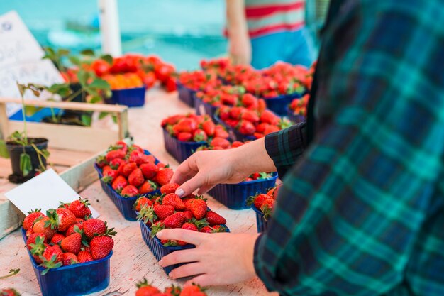 Persona che compra le fragole al supermercato