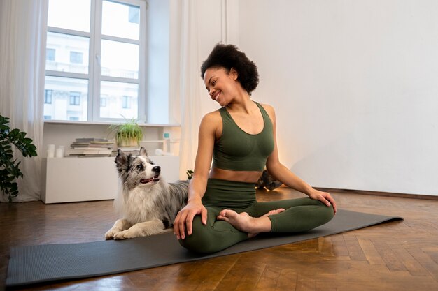 Persona che fa yoga accompagnata dal suo animale domestico