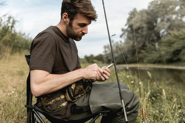 Persona che fissa un amo da pesca