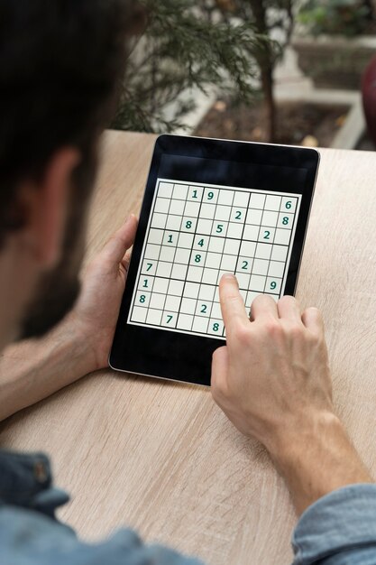 Persona che gioca a un gioco di sudoku su un tablet