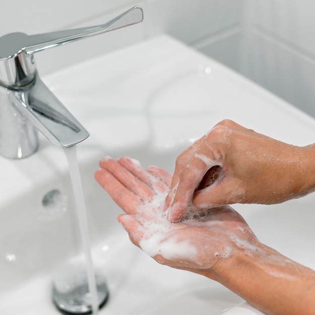 Persona che lava le mani con il primo piano del sapone