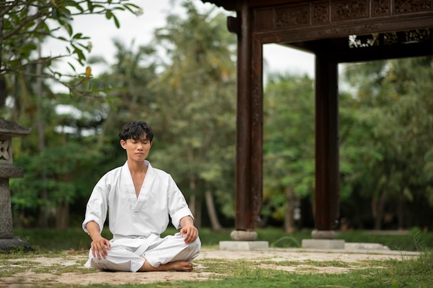 Persona che medita prima dell'allenamento di taekwondo