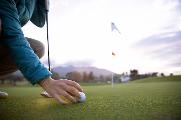 Persona che mira alla bandiera del golf