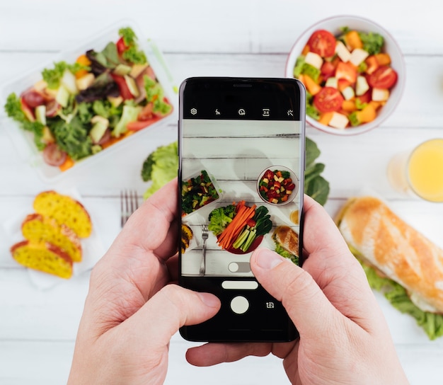 Persona che prende una foto di delizioso cibo sano