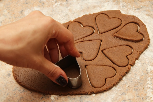 Persona che produce deliziosi biscotti a forma di cuore