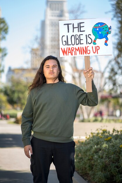 Persona che protesta con il cartello per la giornata mondiale dell'ambiente all'aperto