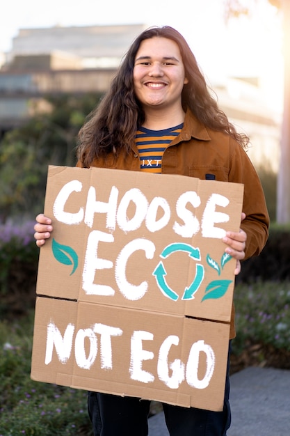 Persona che protesta con il cartello per la giornata mondiale dell'ambiente all'aperto