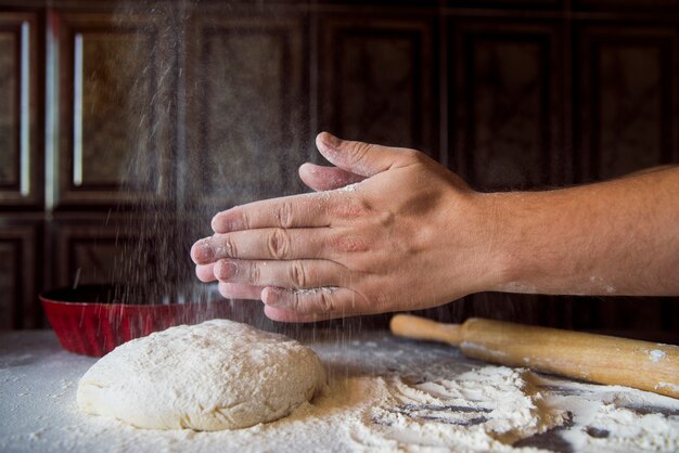 Persona che scuote la farina dalle sue mani