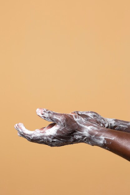 Persona che si lava le mani con il sapone isolato sull'arancia