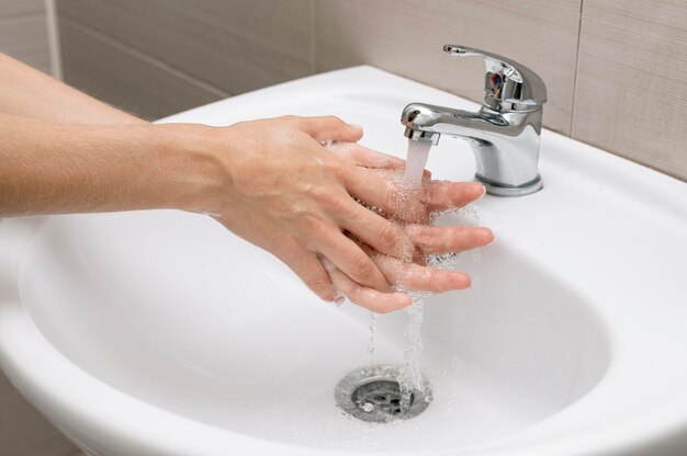 Persona che si lava le mani in un lavandino