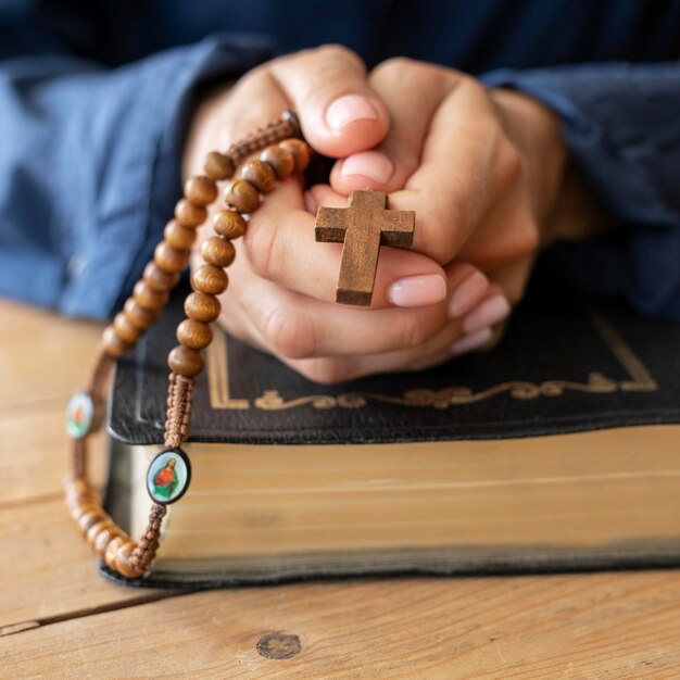 Persona che tiene il rosario in mano e pregando
