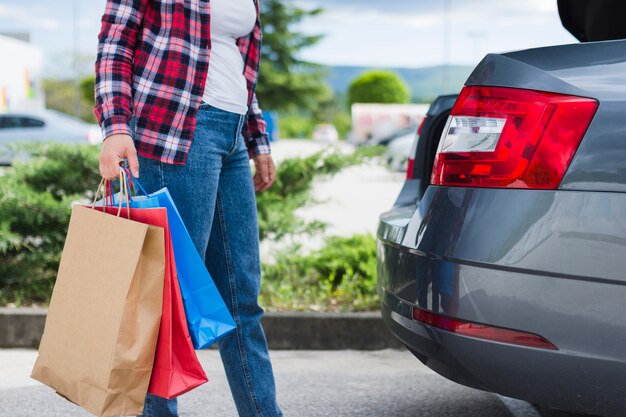 Persona che tiene le borse della spesa all&#39;interno dell&#39;auto