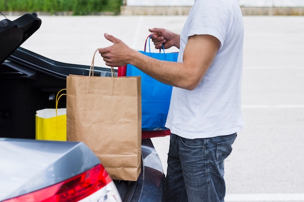 Persona che tiene le borse della spesa all&#39;interno dell&#39;auto