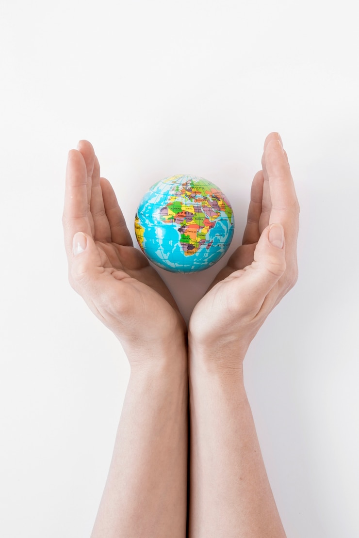 Foto gratuito persona che tiene un globo su fondo bianco