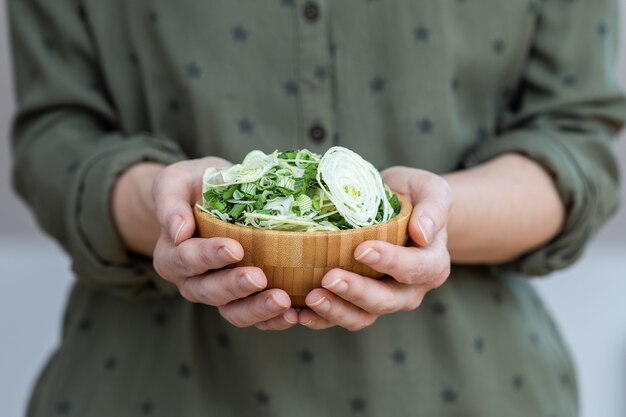 Persona che tiene una ciotola di insalata fatta di cipolle disidratate