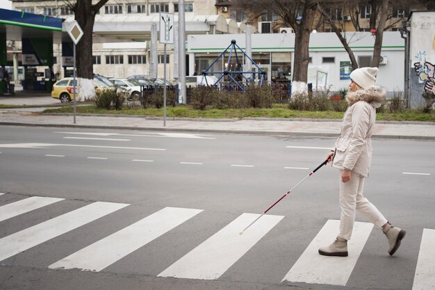 Persona cieca che cammina per la città con un bastone cieco