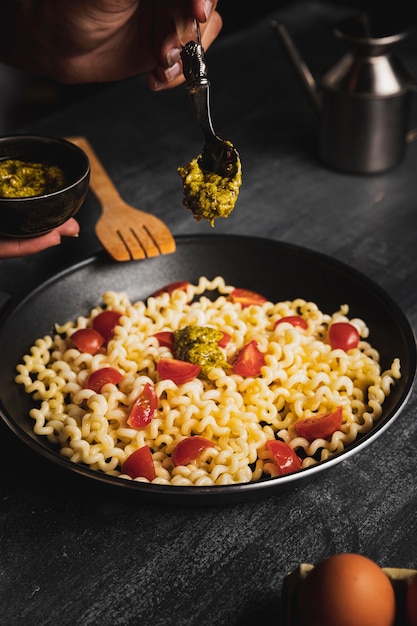 Persona del primo piano che mescola pasta con salsa