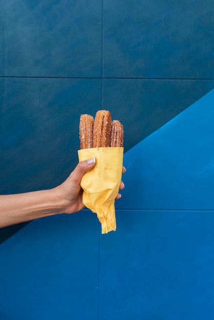 Persona del primo piano che ostacola alimento con fondo blu