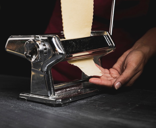 Persona del primo piano con la macchina per pasta