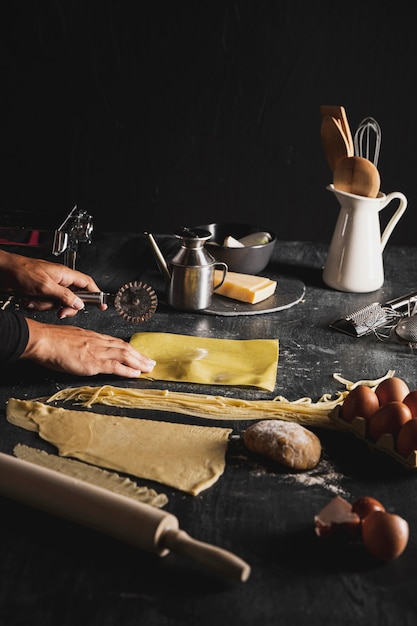 Persona del primo piano con la taglierina e gli utensili della pizza