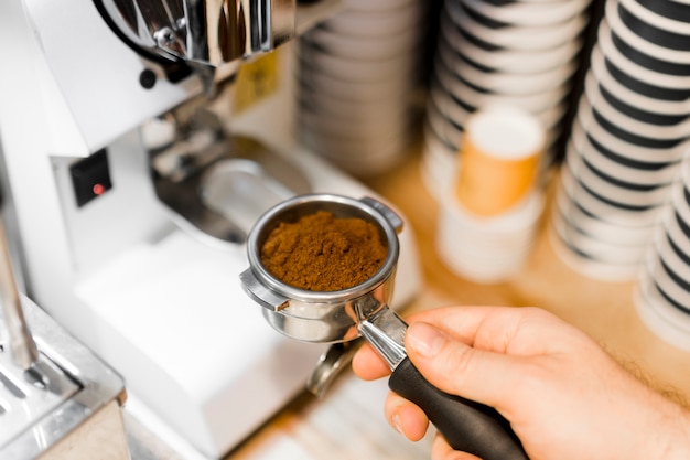 Persona del primo piano con macchina per il caffè