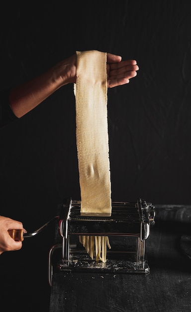 Persona del primo piano con pasta e fondo scuro