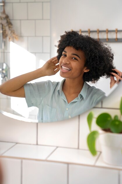 Persona di colore che si prende cura dei propri capelli afro