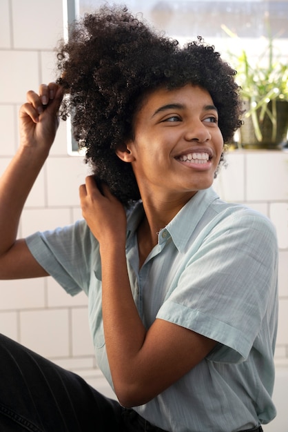 Persona di colore che si prende cura dei propri capelli afro