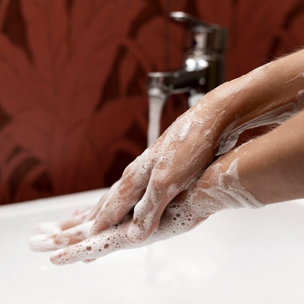 Persona di lato che si lava le mani con sapone solido