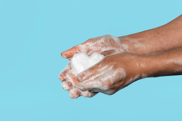 Persona di lato che si lava le mani con un sapone bianco