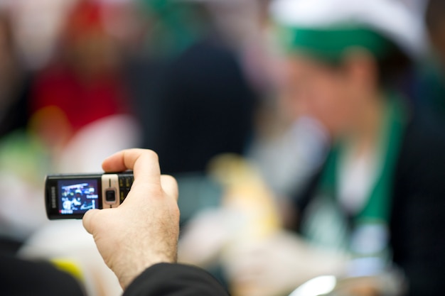 Persona di scattare una foto con un vecchio telefono