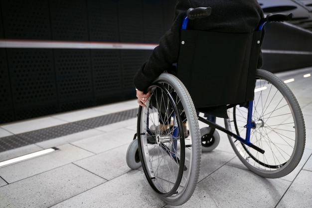Persona di vista laterale in sedia a rotelle alla stazione della metropolitana