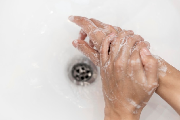 Persona di vista superiore lavarsi le mani con sapone