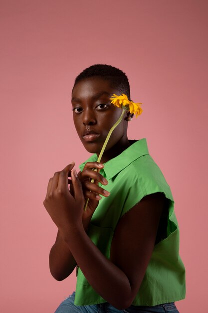Persona fluida di genere africana in posa con una camicia verde