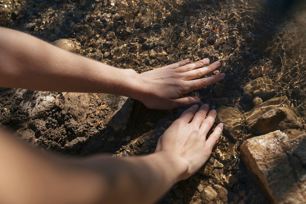 Persona immergendo le mani in acqua