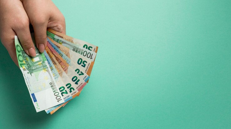 Foto gratuito persona in possesso di banconote con copia spazio