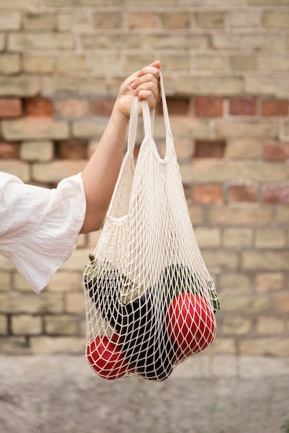 Persona in possesso di borsa biologica con verdure