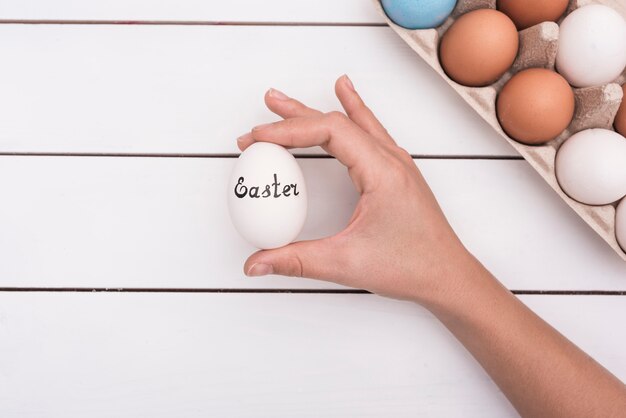 Persona in possesso di uovo con iscrizione di Pasqua