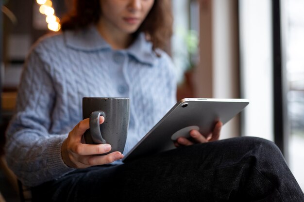 Persona in un bar che legge un libro mentre beve un caffè