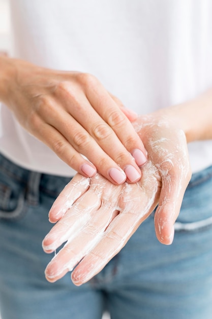 Persona lavarsi le mani con sapone