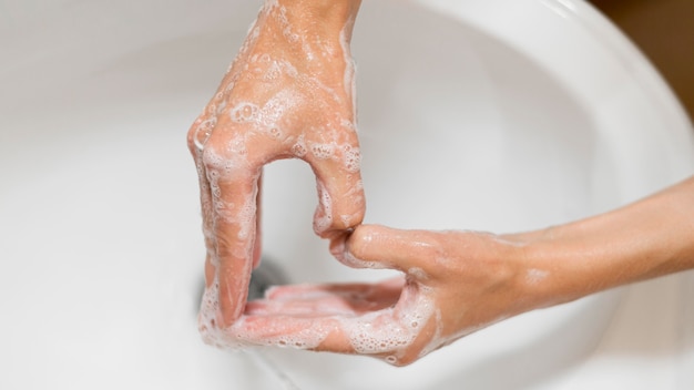 Persona lavarsi le mani con sapone