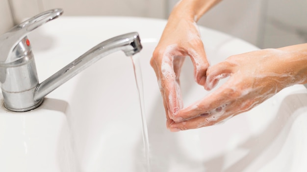 Persona lavarsi le mani con sapone